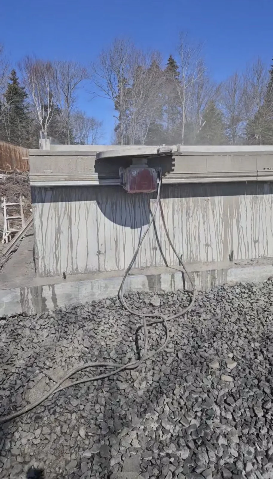 Track-mounted wall saw cutting a concrete foundation wall